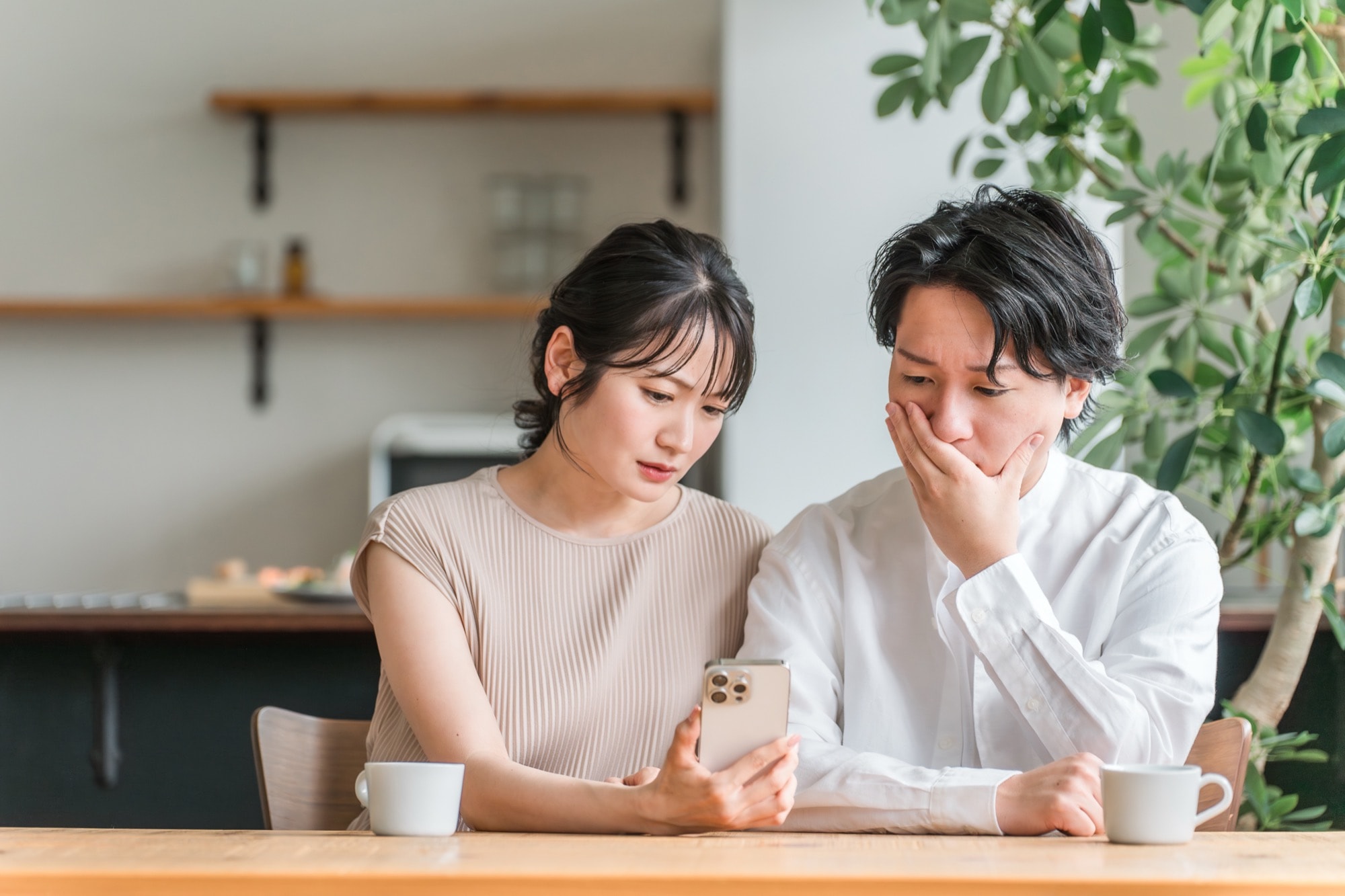 スマホを見て驚く夫婦