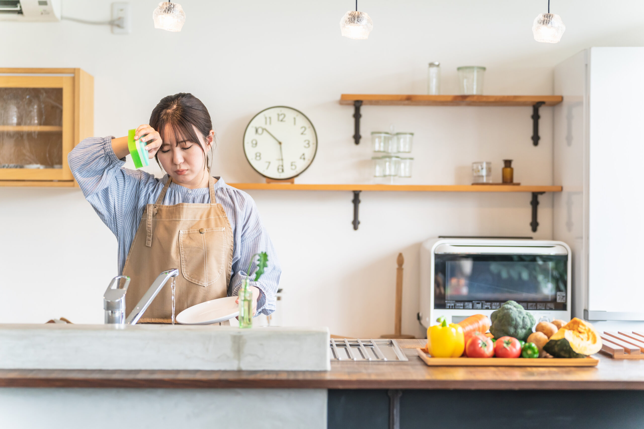 食洗機に入らない食器を洗う女性